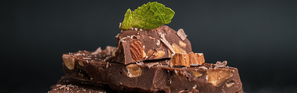 stack of chocolate with almonds and mint leaf on top