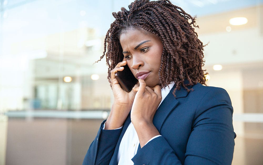 woman work clothes on phone worried