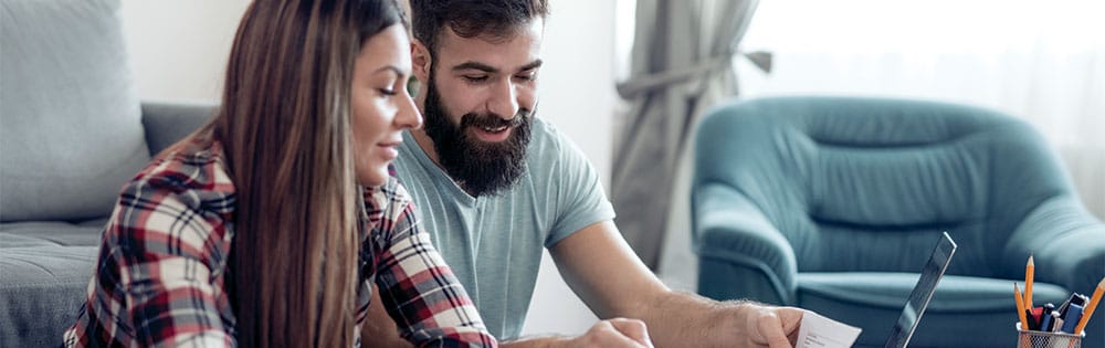 couple look at laptop home