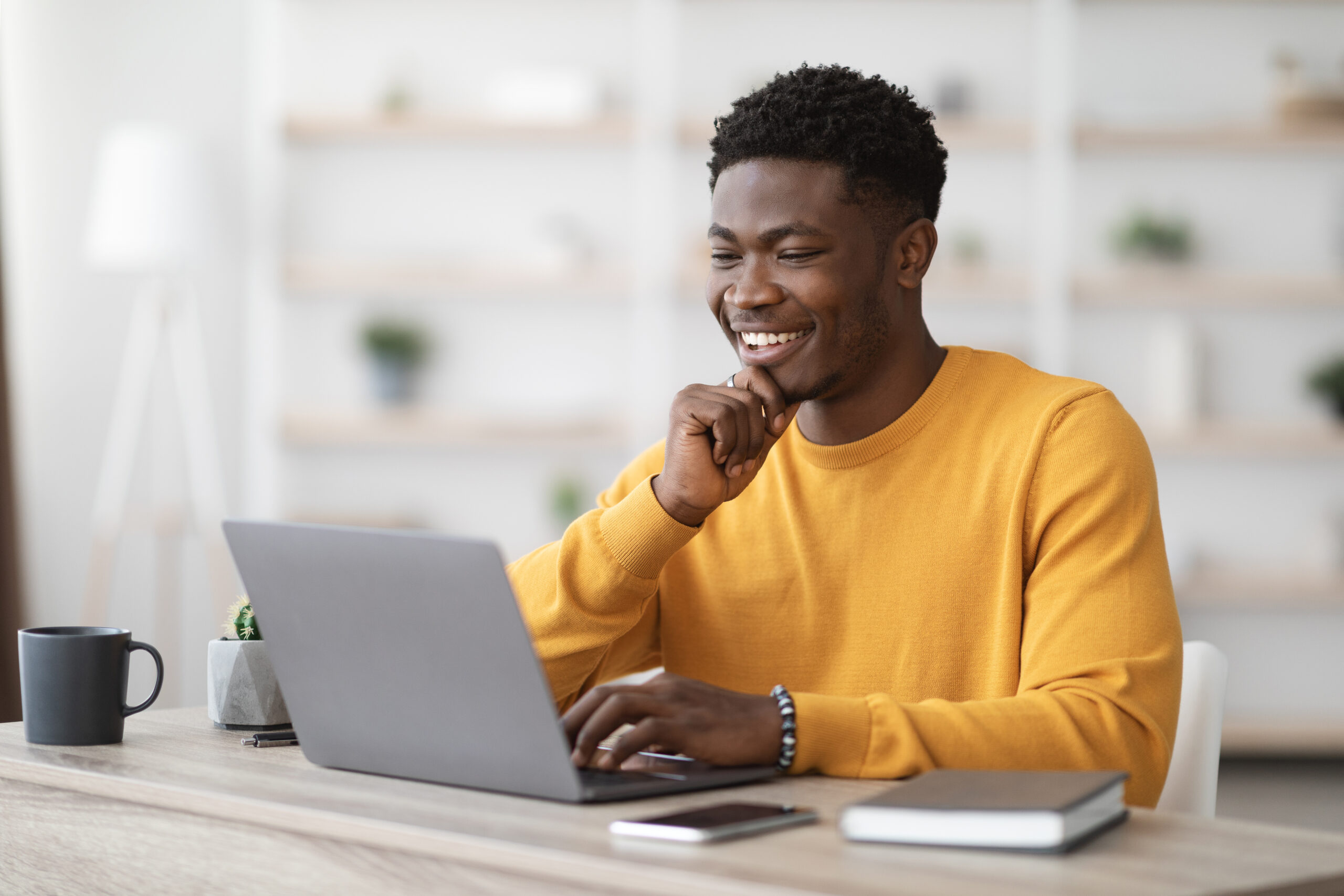 man in yellow shirt at laptop