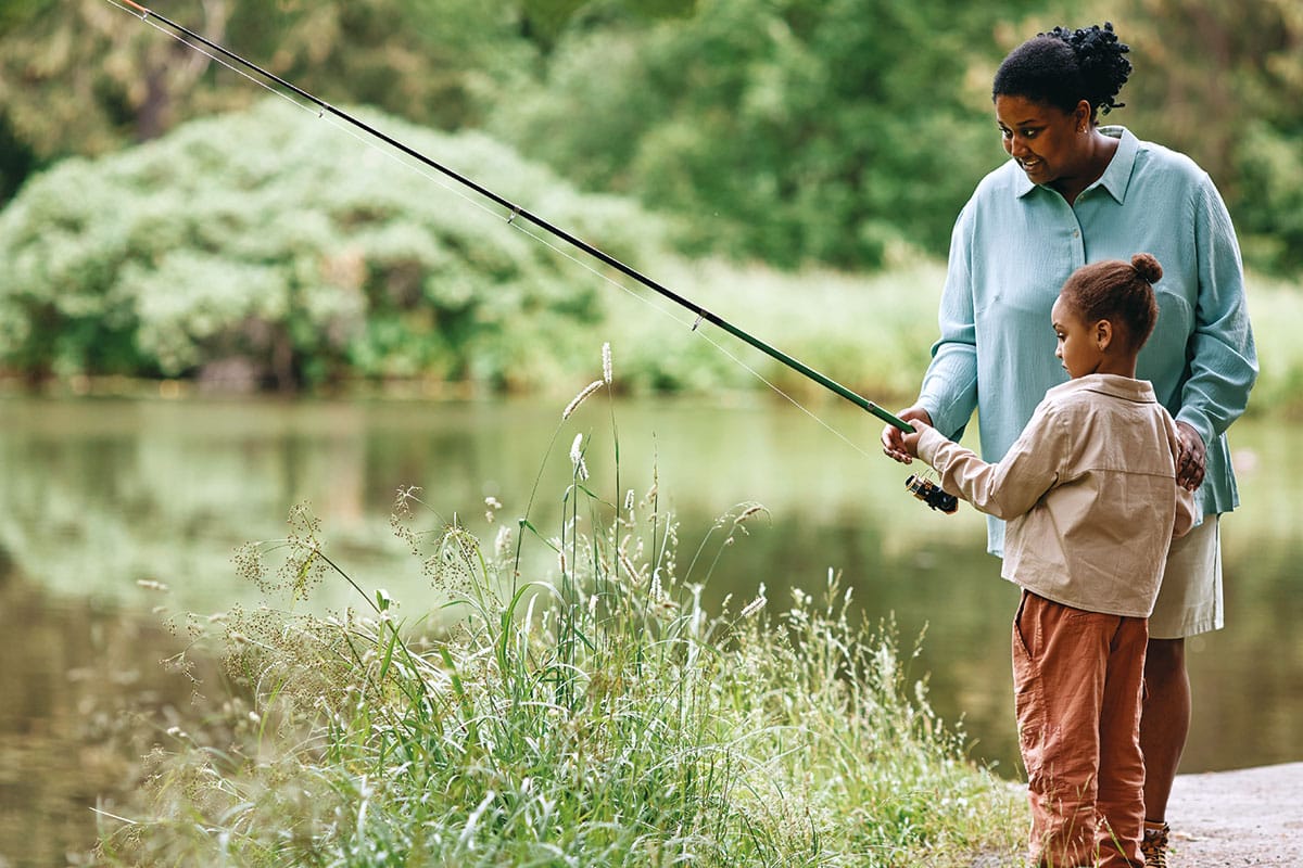 mother and daughter fishing on shore